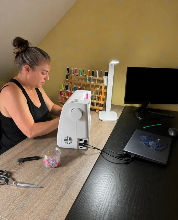 Créatrice des Créations de Maïwen réalisant une création personnalisée dans son atelier de couture en Bretagne.